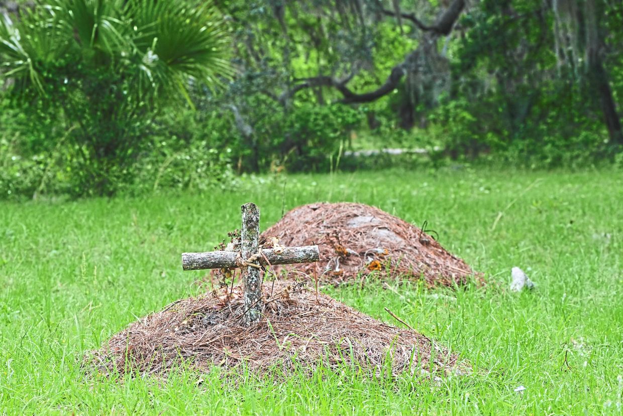 A grave is marked with a cross at the Prairie Creek Conservation Cemetery.