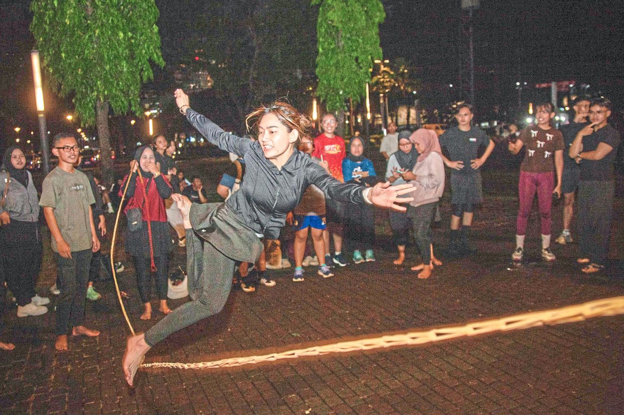 A member of the group takes part in lompat tali karet , an Indonesian children's game.