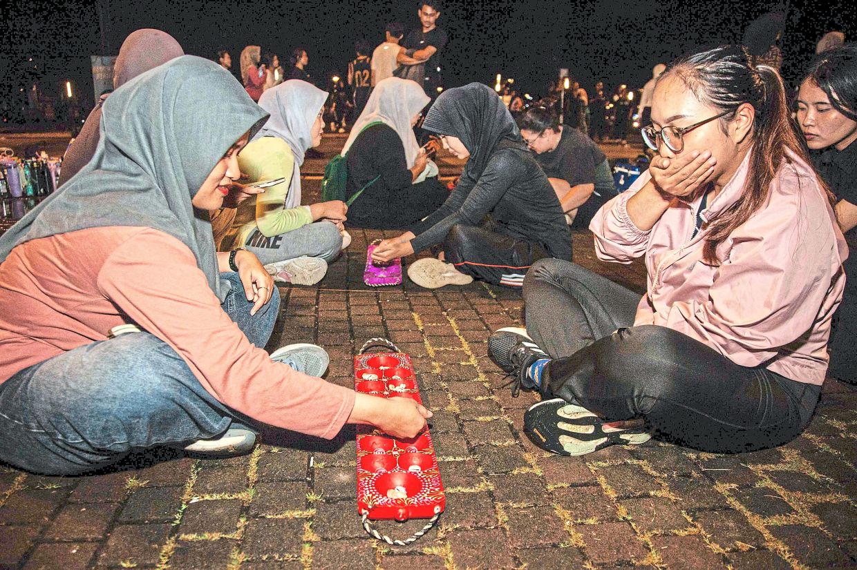 Participants play congklak, another children's game.