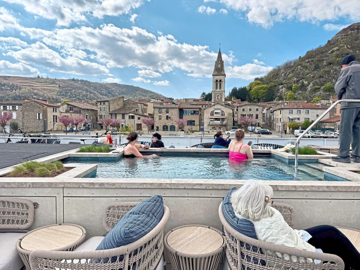 A couple of passengers seen soaking in the ship’s pool while enjoying the views of Andance, a pretty village on the Rhone.