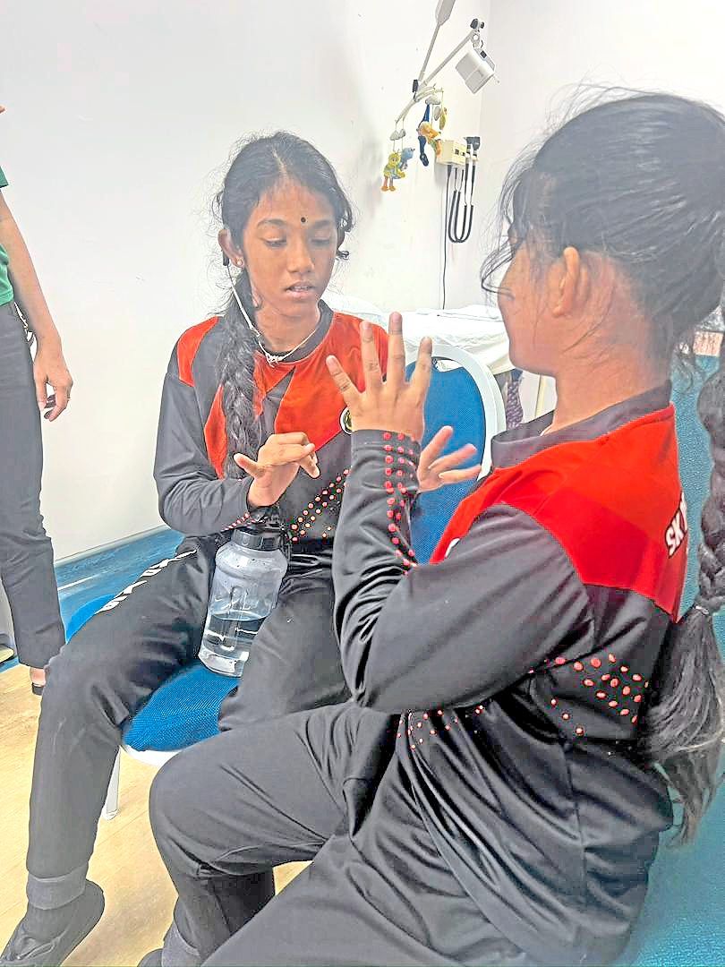Vaaletchumy, who has a cochlear implant, guides Maha through the maths problem presented to her during the clinic visit.