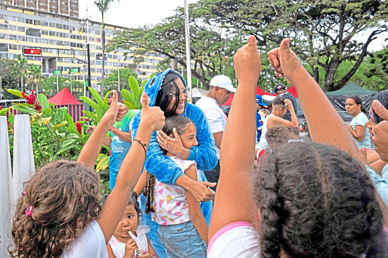5. Volunteers bring moments of joy to displaced children after the earthquakes left their housing complex unsafe to return to in Caracas. — Reuters