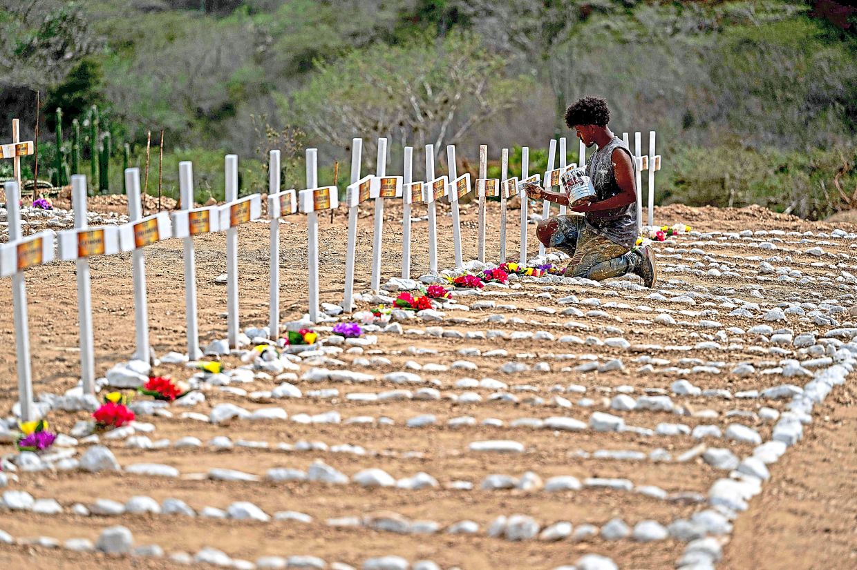 4. A worker painting graves for unidentified earthquake victims at La Esperanza Cemetery in Catia la Mar. The death toll from the twin earthquakes has climbed past 4,000. — AFP