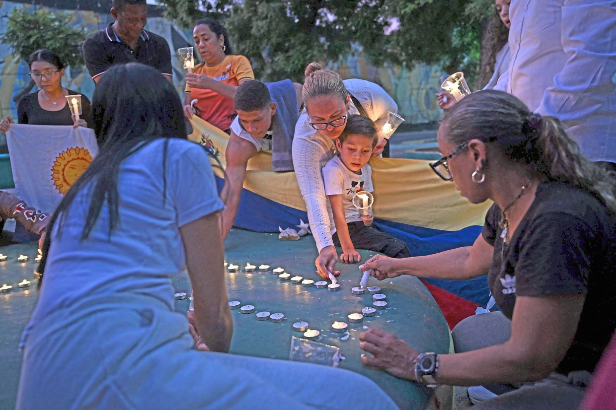 2. People gather with candles during a vigil in Maiquetia, La Guaira state, to honour victims of the twin earthquakes that struck on June 24. — AFP