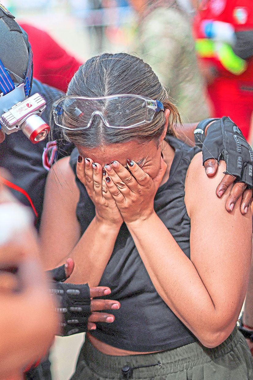 1. A relative breaks down after being told no signs of life were found beneath the rubble of a collapsed building. — Reuters