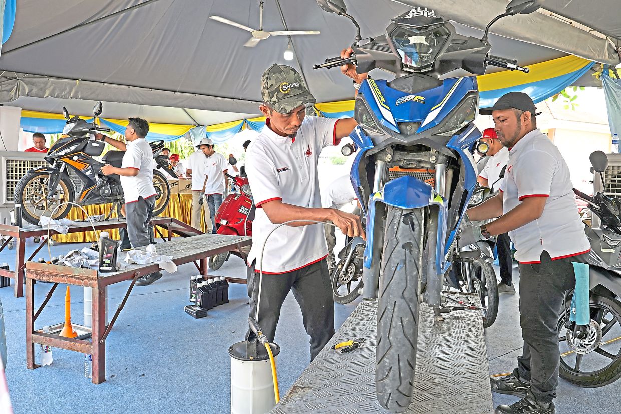 Mechanicsproviding a free engine oil change service during the carnival.