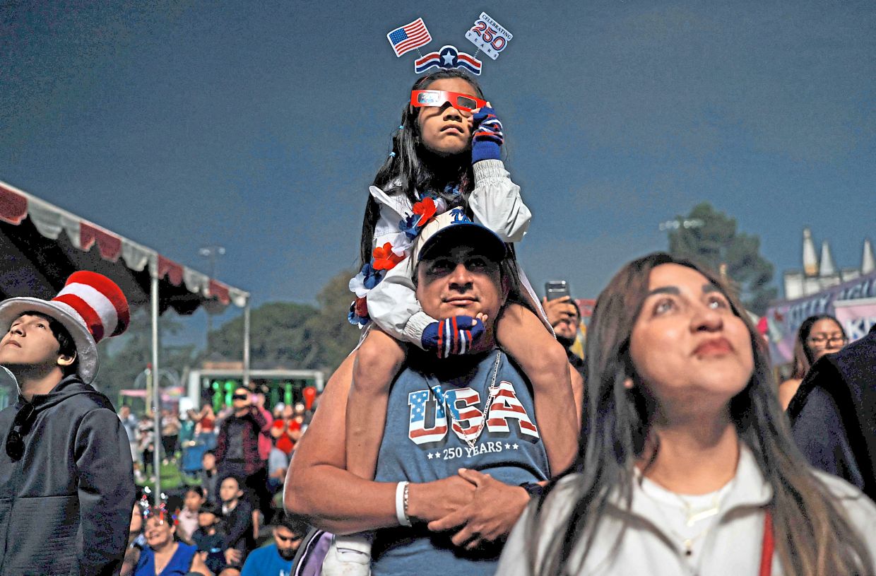 5. A girl watches the fireworks from atop her father’s shoulders during the Independence Day festivities.