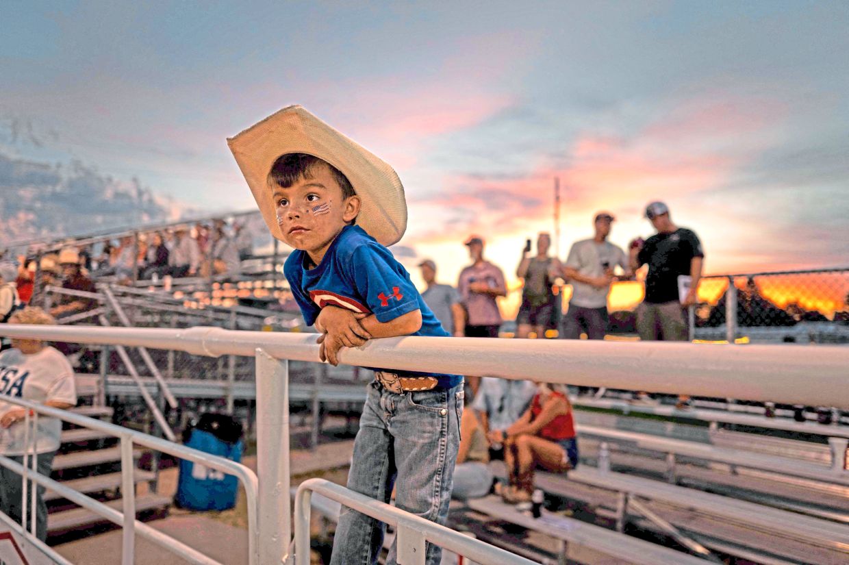 8. A little boy taking in the action at the Independence Day rodeo in Sutherland, Nebraska.