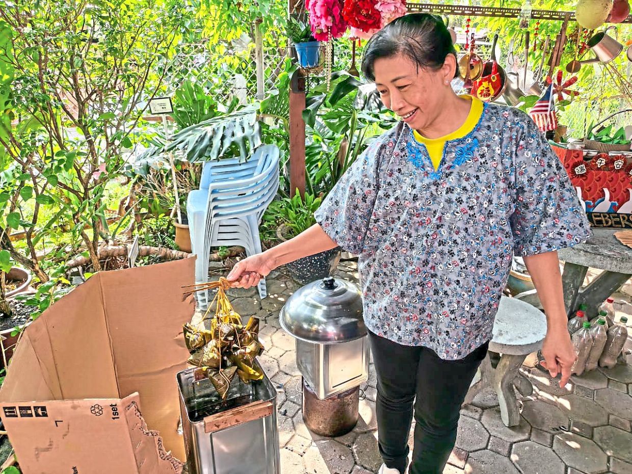 A volunteer demonstrating the traditional method of steaming dumplings using metal drums as part of authentic experiences offered during the event.