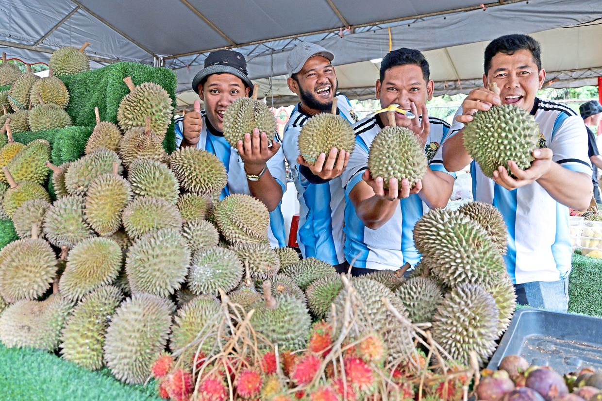 Zulkhairi (second from left) with his co-workers showing off an assortment of durian at the roadside stall in Batu Feringgi, Penang.