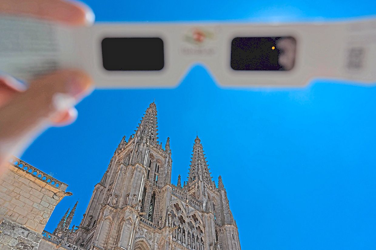A pair of eclipse-viewing glasses with the Burgos Cathedral in the background. Spain is set to experience a total solar eclipse on Aug 12. — AFP