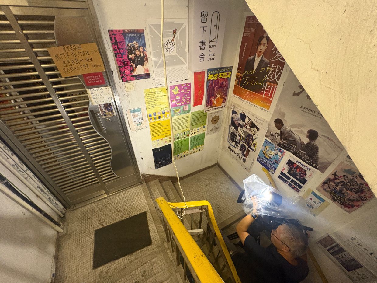 A journalist films the exterior of the independent bookstore Have A Nice Stay in Hong Kong's Prince Edward district on July 15. Photo: AP