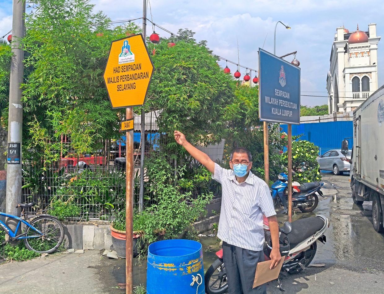 Yee pointing out signage showing the overlapping jurisdiction between MPS and DBKL.