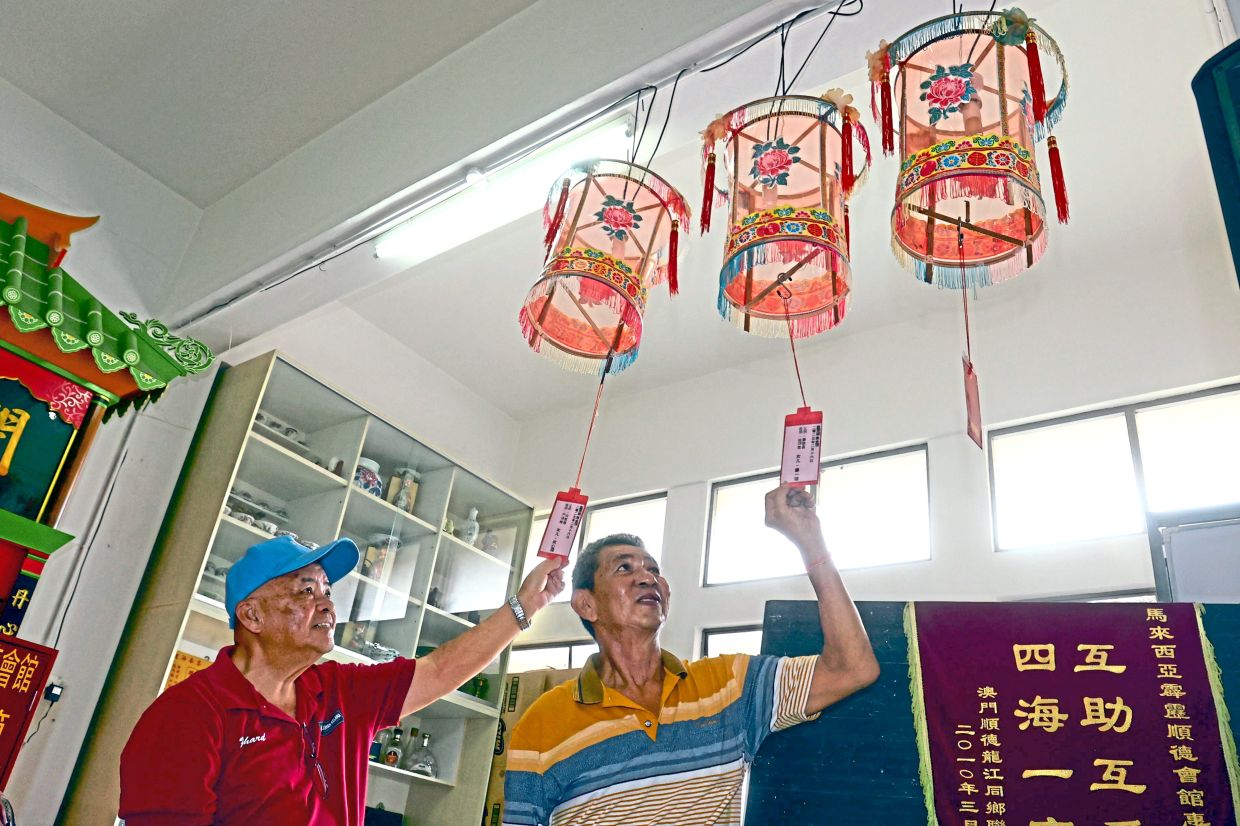 Yoong (right) and Ng showing the names of newborns written on ceremonial lanterns.
