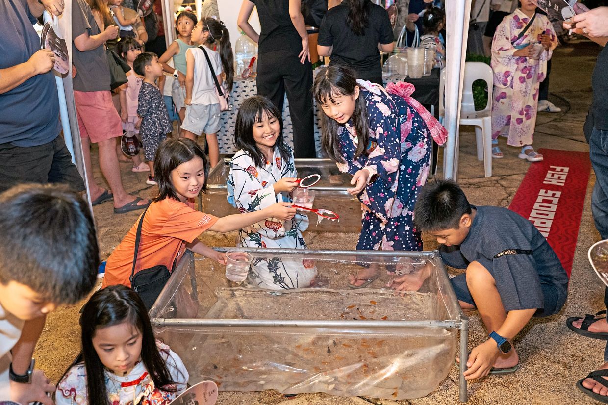 Delighting young and old were authentic Japanese street food, traditional games such as goldfish scooping (right) and brilliant fireworks (far right). — Photos: Handout