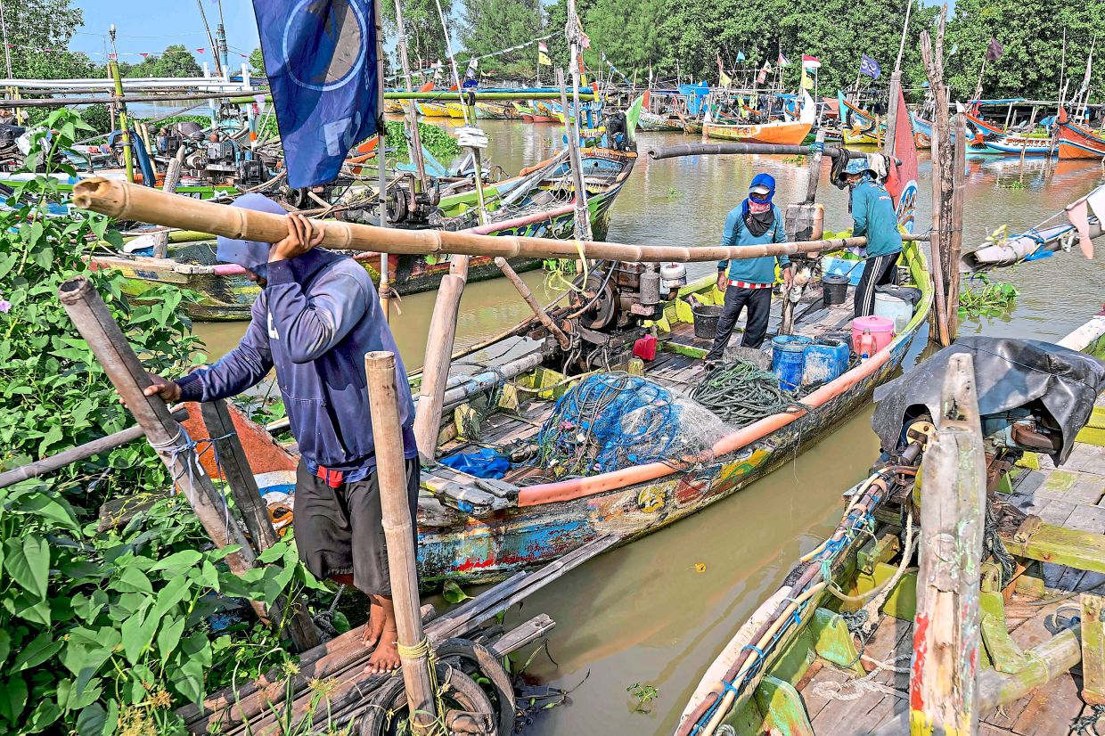 Fishermen moor their boat after returning from sea at the traditional port. — AFP