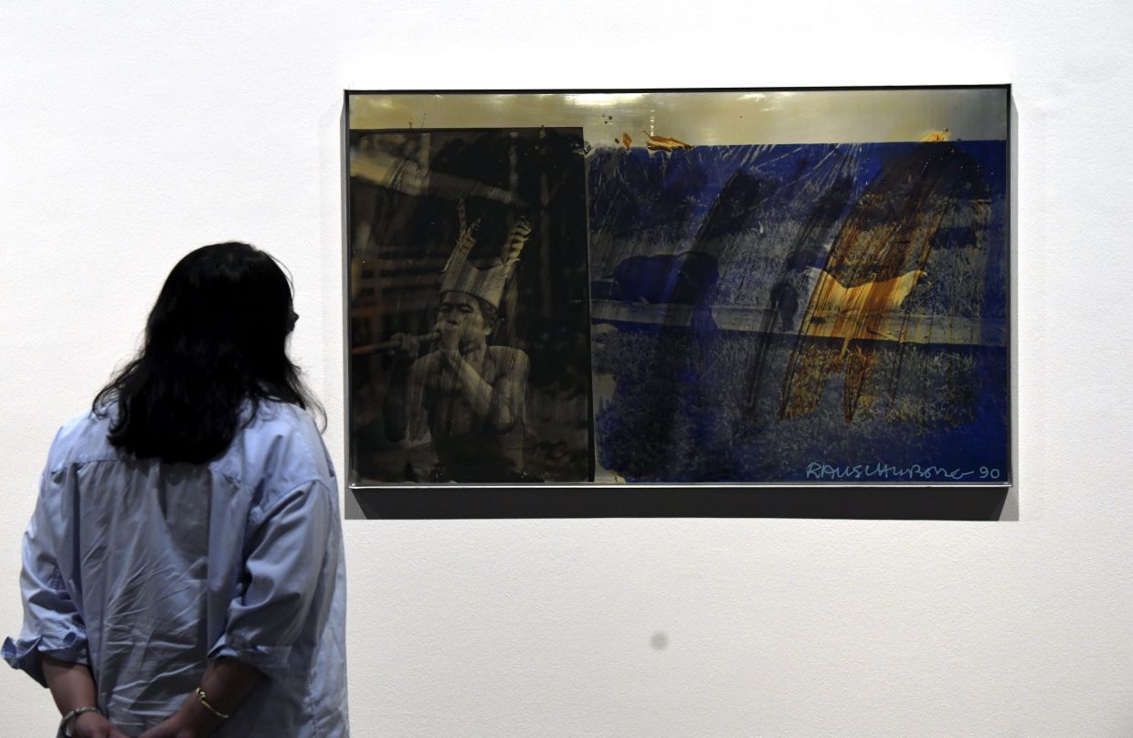 A visitor views one of Rauschenberg's ROCI Malaysia works at the 'Robert Rauschenberg And Asia' exhibition at Ilham Gallery in Kuala Lumpur. Photo: The Star/Azhar Mahfof