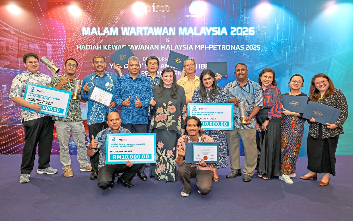 Pride of the newsroom: SMG chief content officer Datin Paduka Esther Ng (fifth from left) and managing editor Brian Martin (fourth from left) celebrating the company’s success with its award winners at the MPI-PETRONAS Malaysian Journalism Awards 2025 in Kuala Lumpur. — Photos by GLENN GUAN/The Star