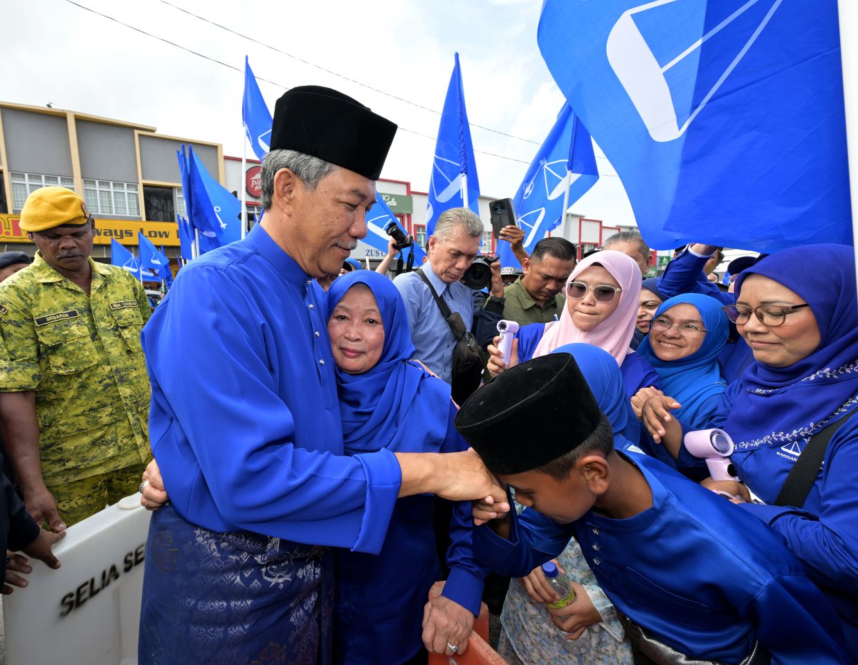 A young supporter greeting Rantau incumbent Datuk Seri Mohamad Hasan and his wife Raja Datin Seri Salbiah Tengku Nujumudin outside the Dewan Seri Rembau nomination centre