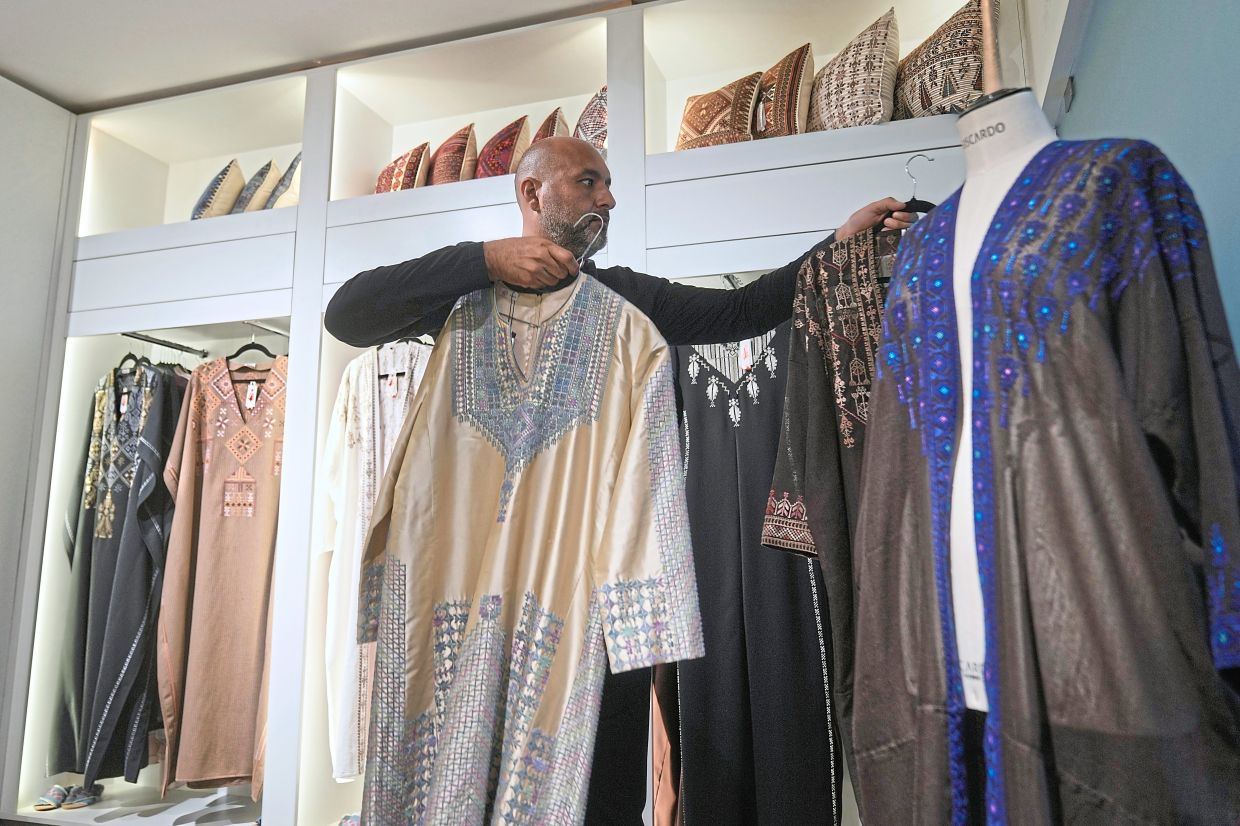 Ali Jaafar, the general manager of Inaash Association, arranges tatreez pieces at the embroidery workshop in Beirut. Photo: AP