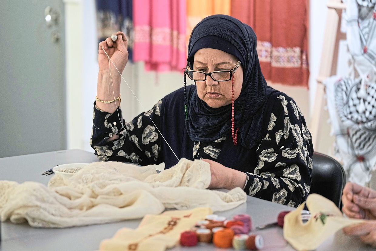 Palestinian weaver Samira Nasser works on a handmade embroidered piece at the Inaash Association embroidery workshop in Beirut. Photo: AP