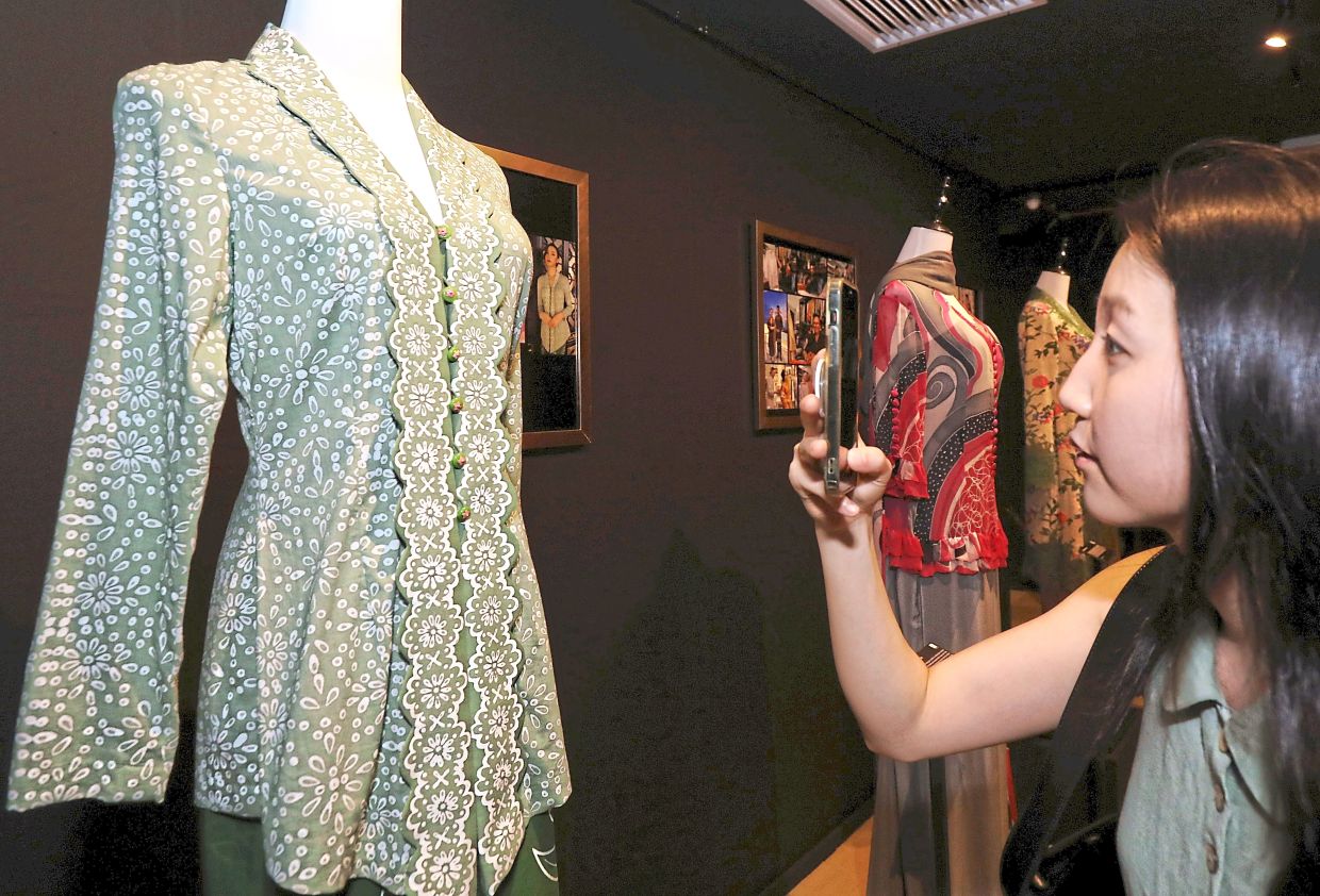 A visitor admiring the intricate designs of the kebaya.