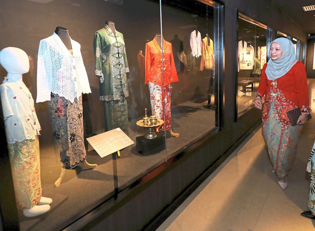 A visitor walks past a display on how the kebaya has changed with time through its design, materials and functions, reflecting its transformation while preserving its cultural identity.