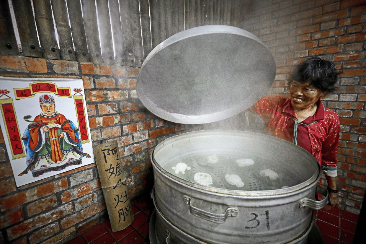 An elderly resident checking on the freshly steamed buns at Dongluo River Leisure Farm.