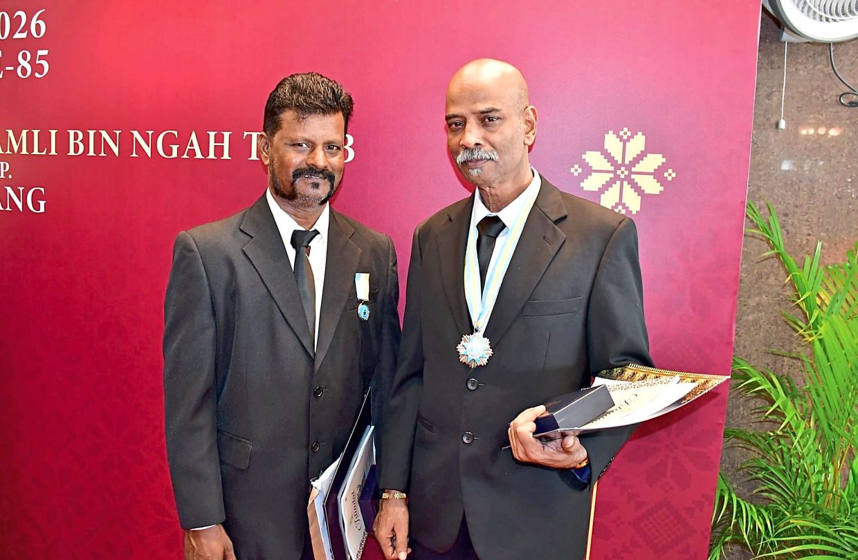 Murugesu (right) and Selvam wearing the medals conferred by the Penang governor.
