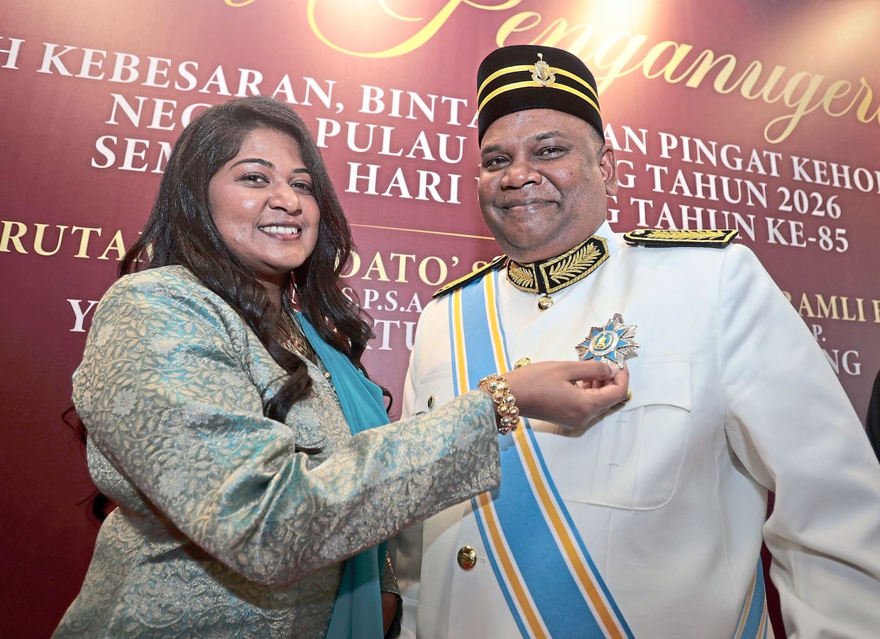 Datin Hilda Grace Galerial showing the Darjah Setia Pangkuan Negeri medal her husband Arumugam received.
