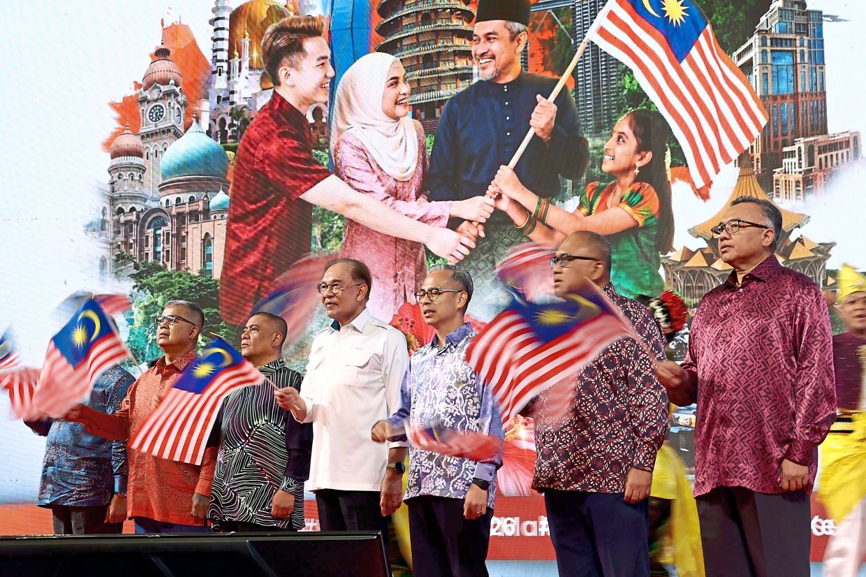 Patriotic spirit: Anwar waving a Jalur Gemilang along with distinguished guests after launching the National Month and Fly the Jalur Gemilang 2026 event held at the Sultan Azlan Shah Health Ministry Institute for Health Training. — RONNIE CHIN/The Star
