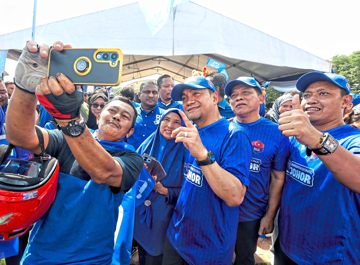 All smiles: Team Barisan posing for a picture with Onn Hafiz (centre) after the election machinery meeting at Dataran Kampung Tengah in Gemencheh. — MUHAMAD SHAHRIL ROSLI/The Star