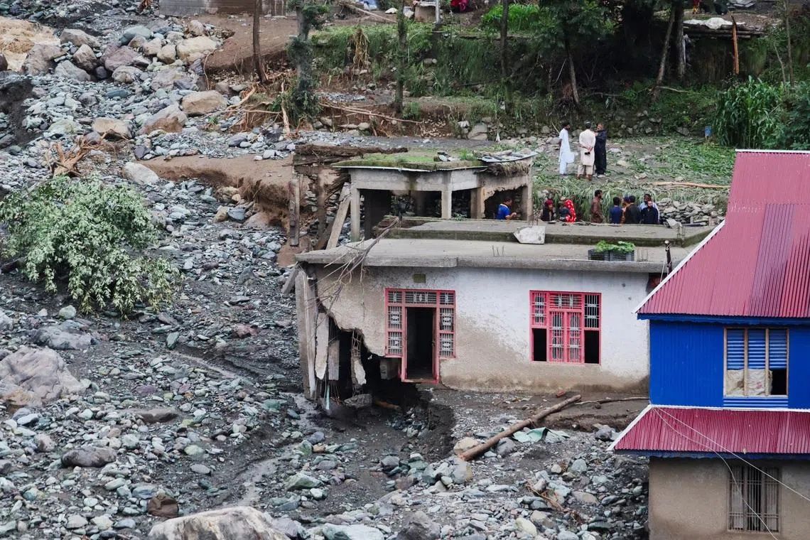 People stand near a house damaged due to a flash flood, in Poonch, Indian Kashmir, July 19, 2026. - Photo: Reuters