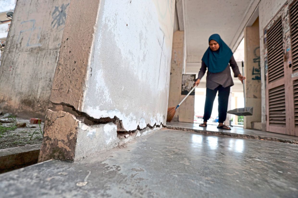 A resident sweeping up at a low-cost flat in Taman Bagan, one of the areas being looked at for long-needed infrastructure upgrades.