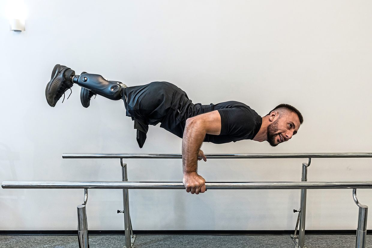 Denys Ivashchenko, a Ukrainian war veteran who was wounded in August 2025, doing strength training at the Protez Foundation in Kyiv, on May 27. — Oksana Parafeniuk/The New York Times