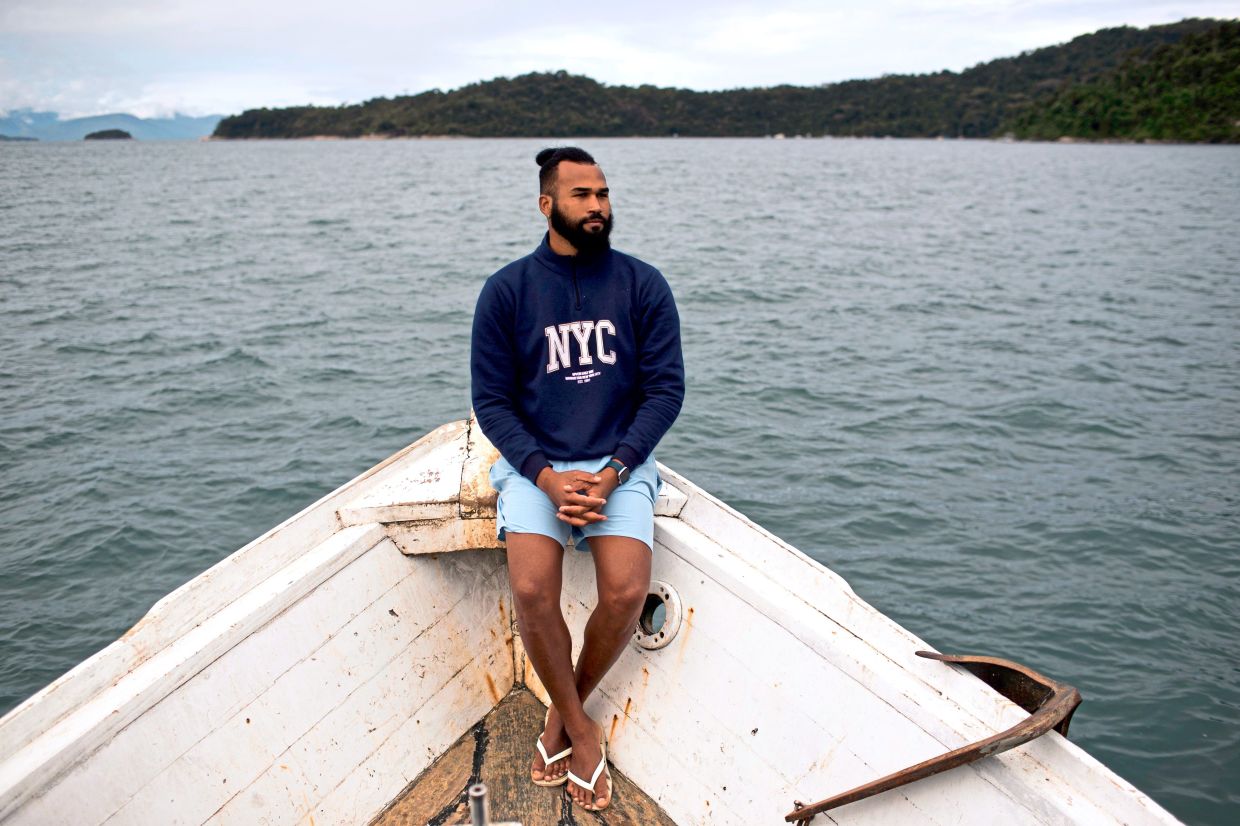 Fisherman Reinaldo Dias da Rocha, from the Guariba community, rides aboard a boat in Ilha Grande Bay.
