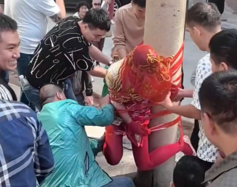 Public backlash over video of a Chinese bride taped to a utility pole sparks fierce debate over extreme wedding hazing. - Weibo