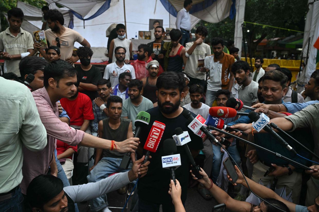 Cockroach Janta Party founder Abhijeet Dipke speaking to the media during a protest demanding the resignation of India's Education Minister Dharmendra Pradhan over alleged NEET exam irregularities, in New Delhi on July 21, 2026. - AFP