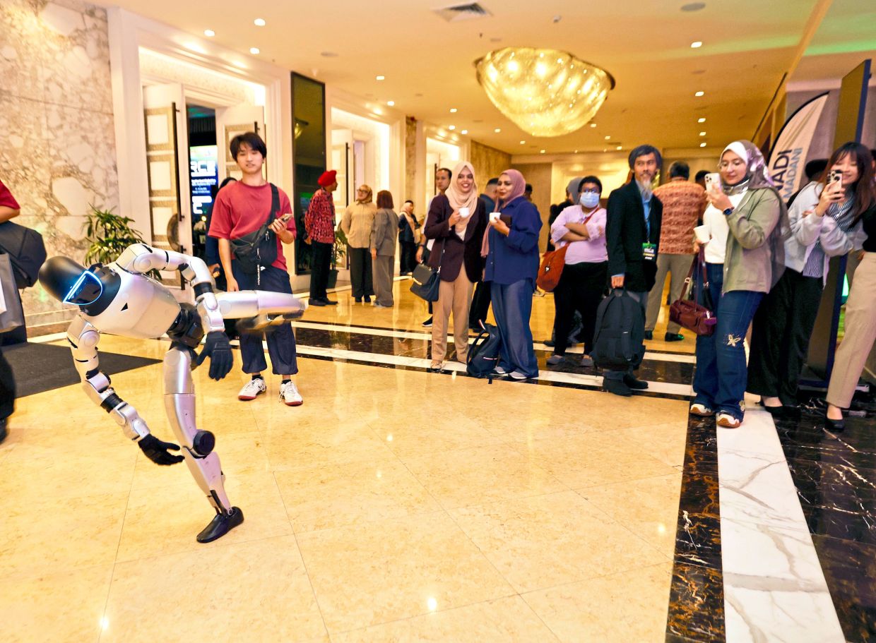 Technology in action: (From left) Fernandez speaking at IRC 2026; guests watching a performance by Unitree G1 at the event.