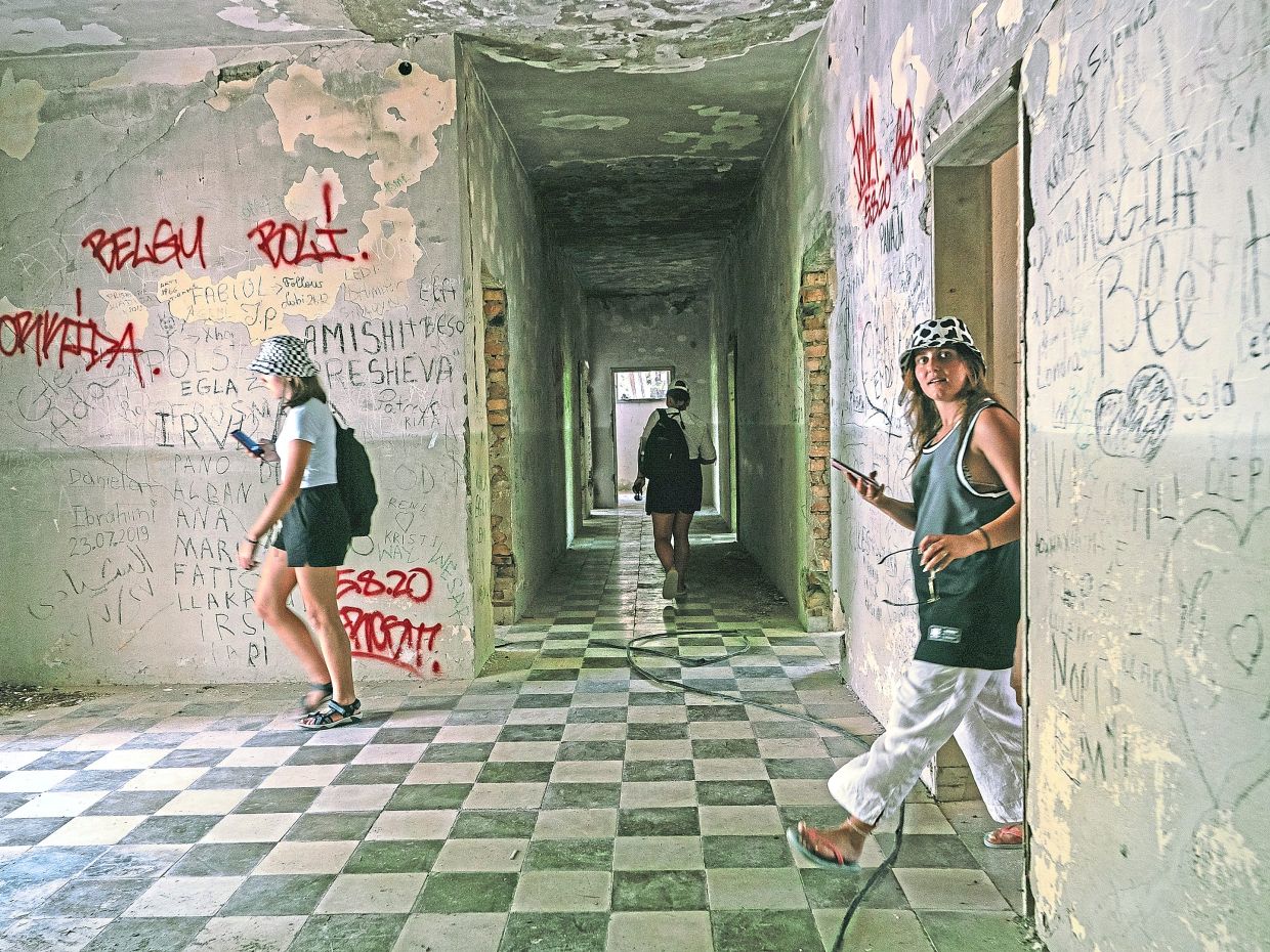 Tourists exploring abandoned military buildings on Sazan Island in this file pic from July 14, 2024. — Ilir Tsouko/The New York Times