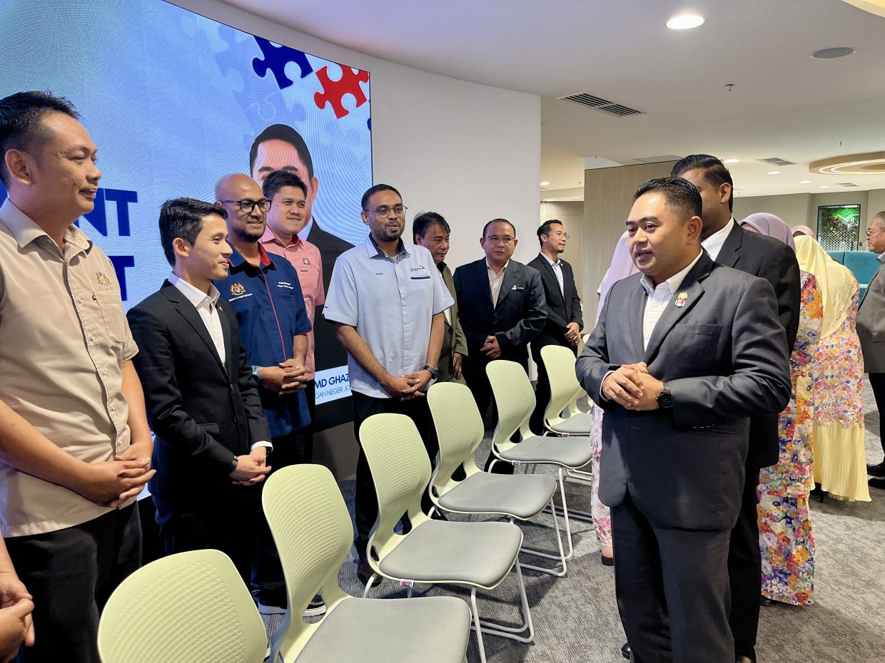 Johor education and information committee chairman Dr Muhammad Naqib Md Ghazali (right) having a chat with department representatives after a meeting with them.