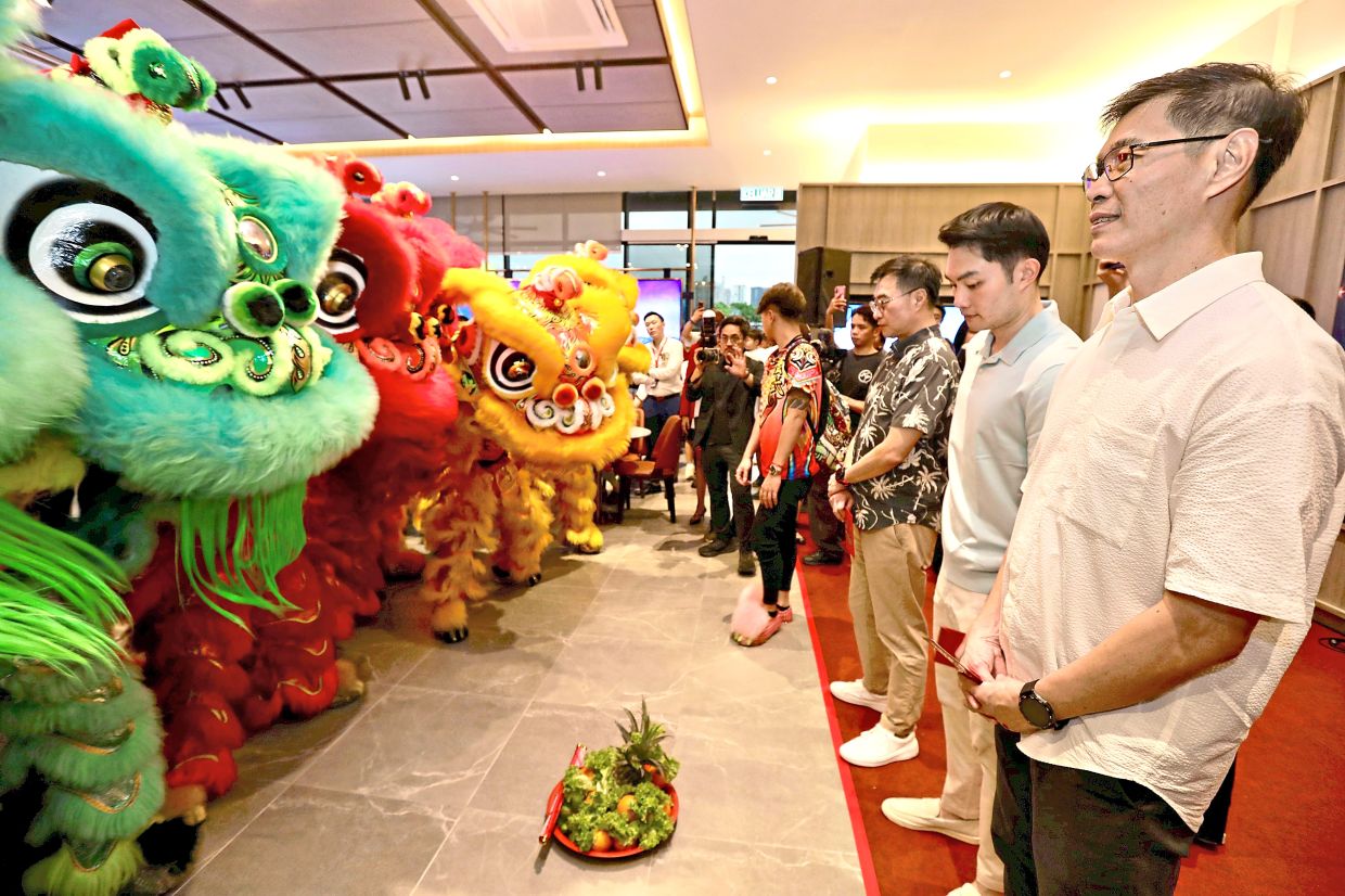 (From right) Wong, Ter and Tan standing opposite lion dance performers during the launch of Sunsuria Bhd’s new sales gallery. 