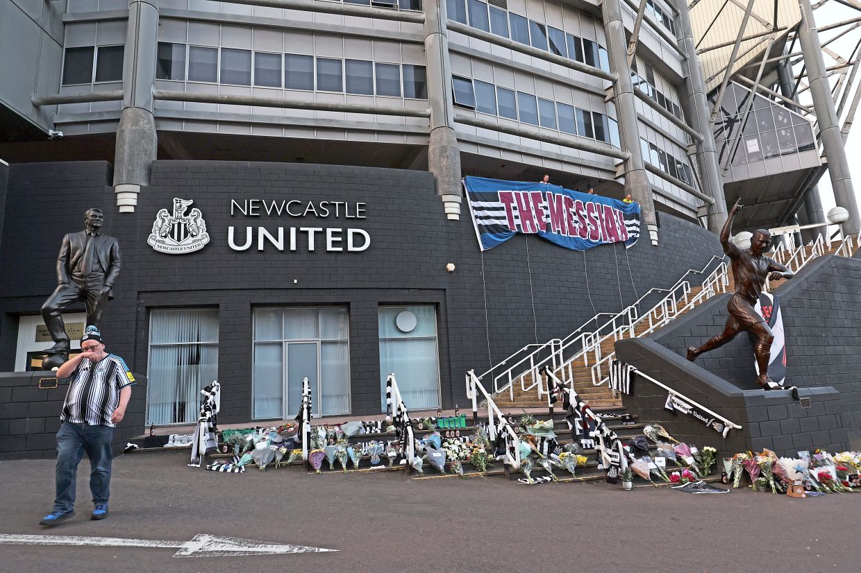 Newcastle United fans pay respect as shirts and flowers are laid outside St James' Park.