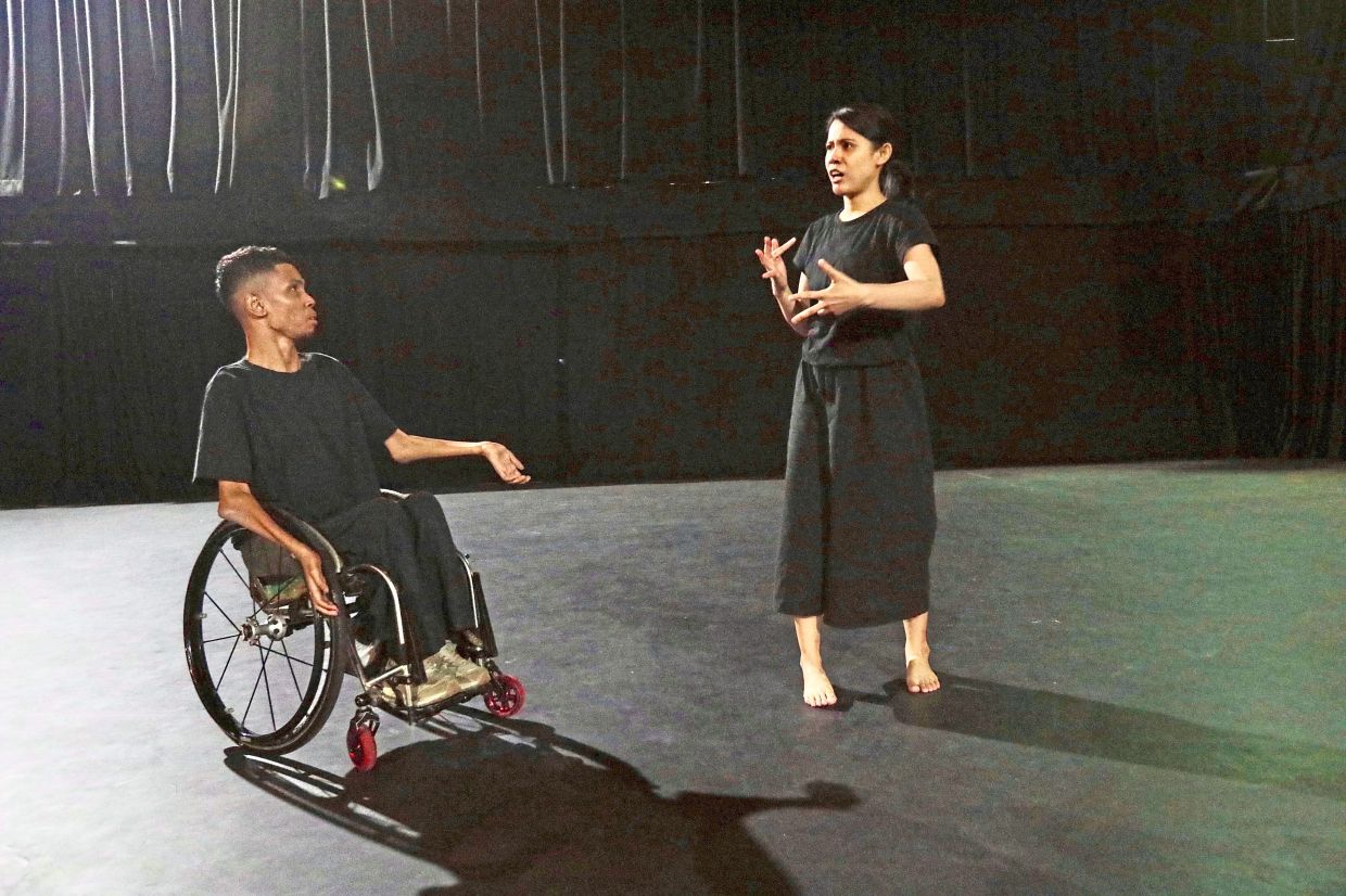 Wheelsmith (also known as Danial Bawthan) and Ho Lee Ching (right) rehearse a scene from 'Being Carried', a theatre production centring disabled, Deaf and neurodivergent artists. Photo: The Star/Low Lay Phon