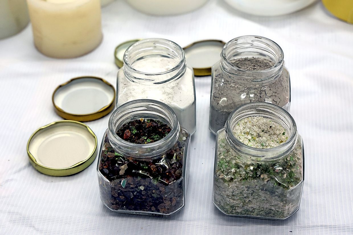 Used glass bottles are cleaned, sorted and crushed before being crafted into handmade items.