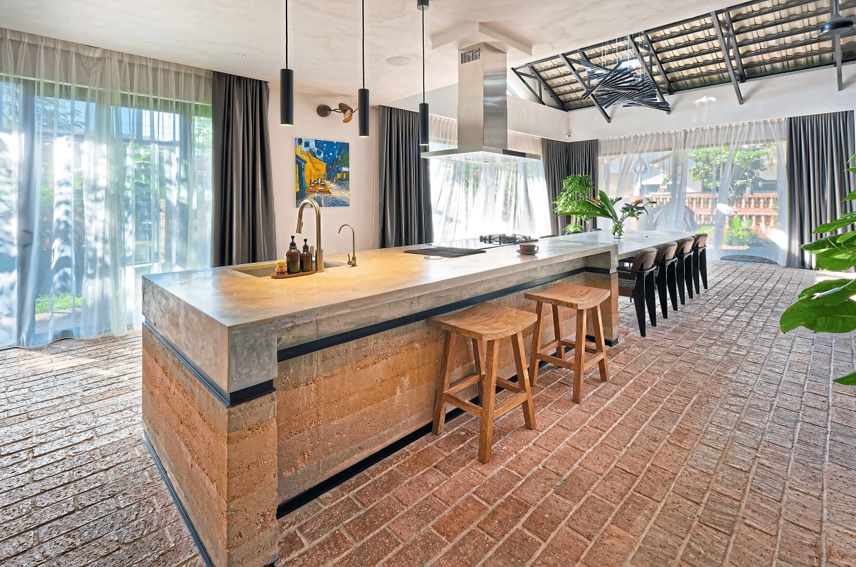 The rustic kitchen with rammed- earth island, polished concrete top and brick flooring.