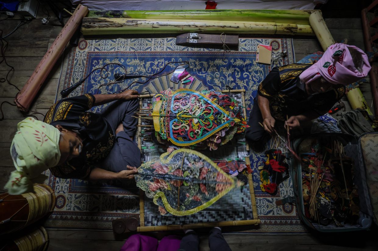 Kelantan wayang kulit musicians carefully rearrange and store the puppets used after each performance to prevent damage. Photo: Bernama 