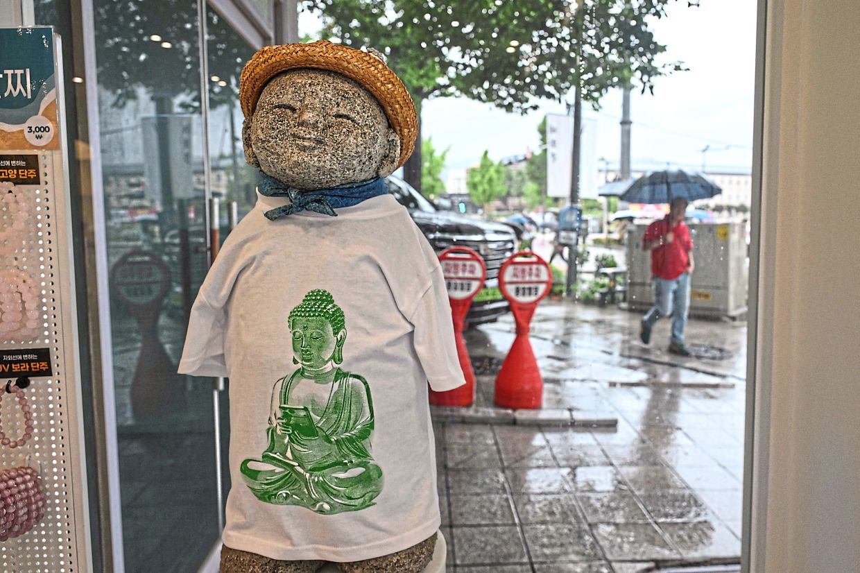 A smiling mannequin wearing a Buddha-themed T-shirt. — AFP