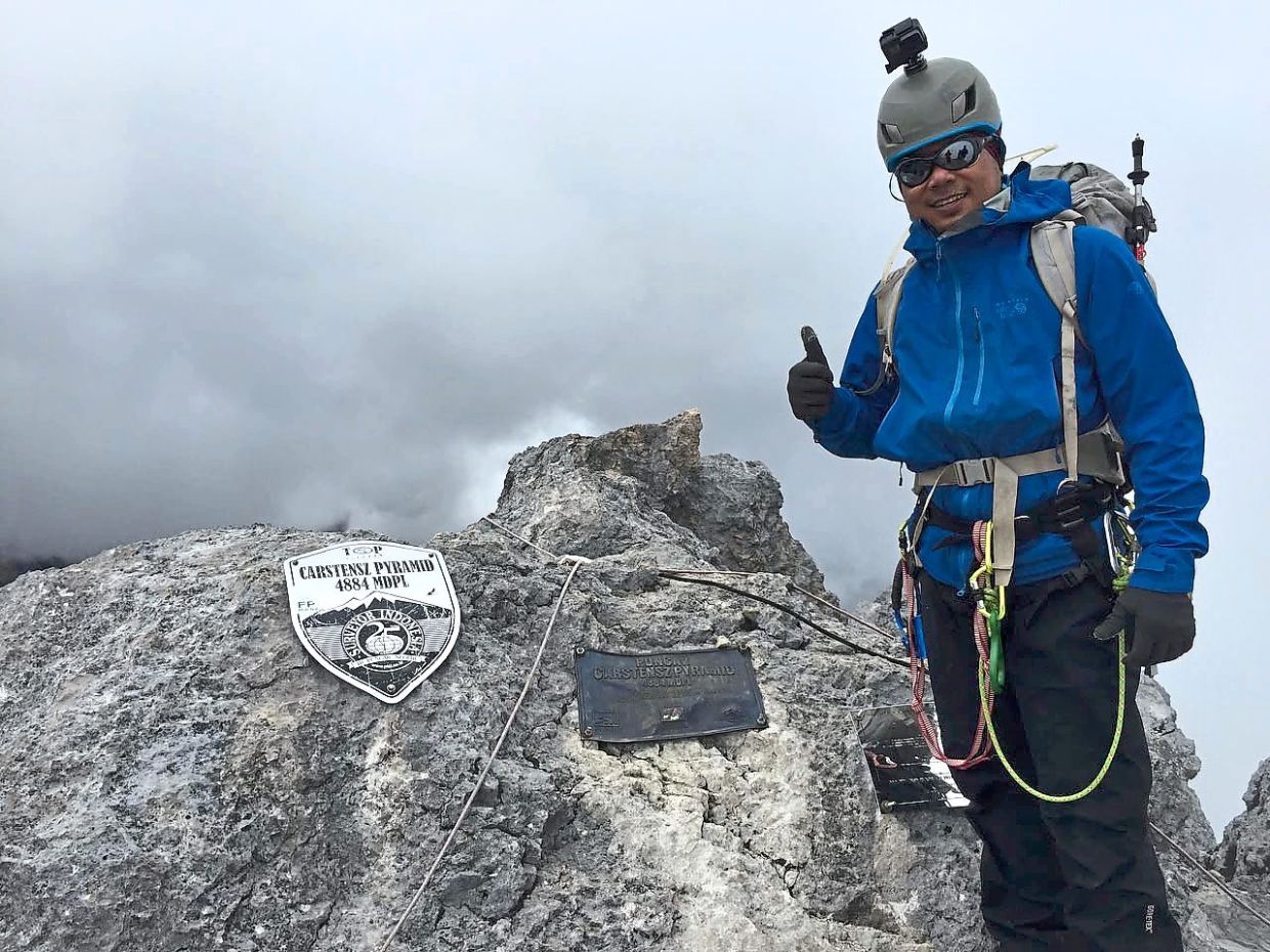 Khafiz at the peak of the Carstensz Pyramid in Western New Guinea or Papua, Indonesian New Guinea, one of the toughest mountains to climb.