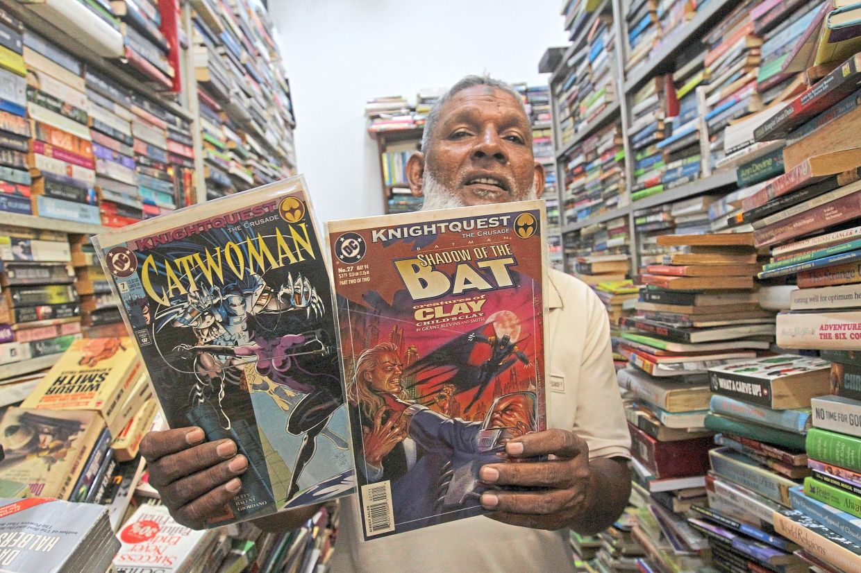 Anur showing some of the comic books sold at his bookstore located on the first floor of Chowrasta Market in George Town.